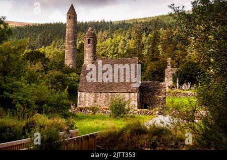 Steiles Steindach und runder Turm der St. Kevins Church in Glendalough, Irland. Stockfoto