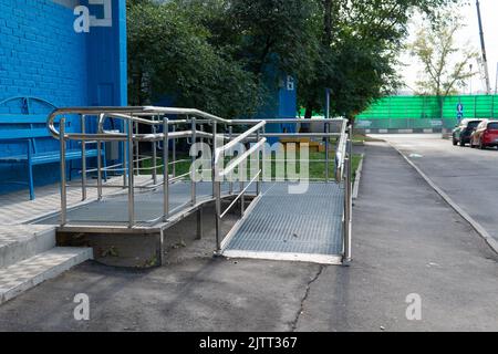 Zugangsrampe Rollstuhl Behindertenzugang Stuhl Gebäude Person, von Hangbehinderung in zu Hause und Rutsche Sonne, Straße Detail. Haus Kieselstein, Stockfoto