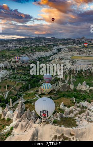 GOREME/TÜRKEI - 26. Juni 2022: Bunte Heißluftballons fliegen bei Sonnenaufgang in der Nähe von goreme, wetteifern vom Ballon Stockfoto