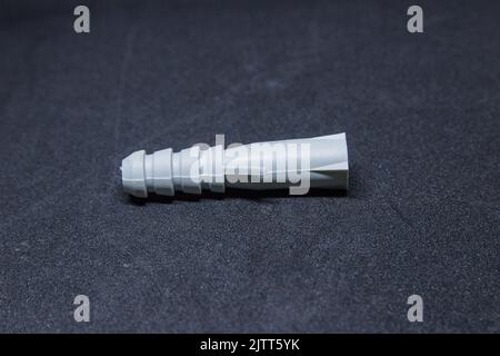 Dübel in weißer Farbe zur Befestigung der Schraube. Stockfoto