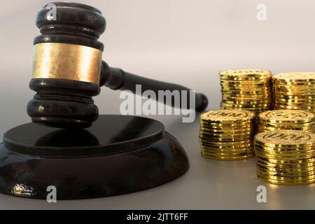 Richter-Gavel mit Haufen Goldmünzen auf dunklem Hintergrund. Stockfoto