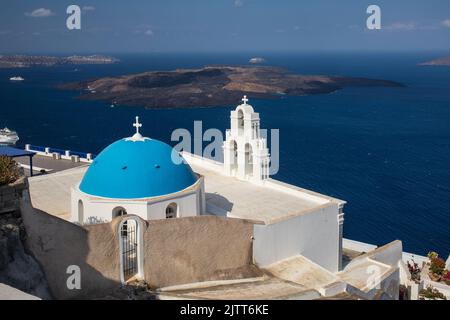 Die katholische Kirche der Dormition - drei Glocken von Fira mit seiner blauen Kuppel mit Blick auf die Ägäis und den Vulkan, Fira, Santorini Insel, Griechenland Stockfoto