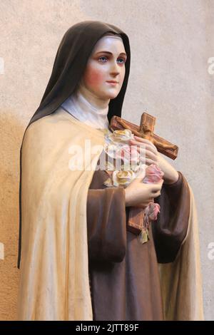 Marie-Bernadette Soubirous Pächter un Crucifix et des Roses. Statue. Collégiale Saint-Jacques-le-Majeur. Sallanches. Haute-Savoie. Auvergne-Rhône-Alpes Stockfoto