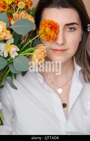 Porträt einer nachdenklichen Frau mit Blumenstrauß Stockfoto