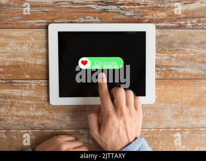 Nahaufnahme der Hand mit Spendensymbol auf dem Tablet-pc Stockfoto