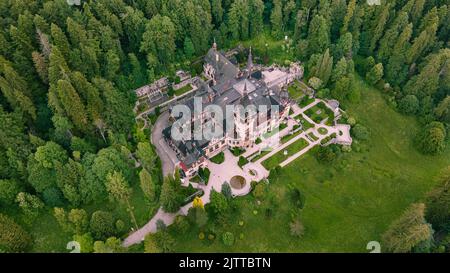 Luftaufnahmen von Schloss Peles in Rumänien. Die Fotografie wurde von einer Drohne in einer höheren Höhe aufgenommen, wobei die Kamera nach unten in Richtung Burg zeigte Stockfoto