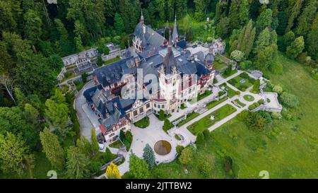 Luftaufnahmen von Schloss Peles in Rumänien. Die Fotografie wurde von einer Drohne in einer höheren Höhe aufgenommen, wobei die Kamera nach unten in Richtung Burg zeigte Stockfoto