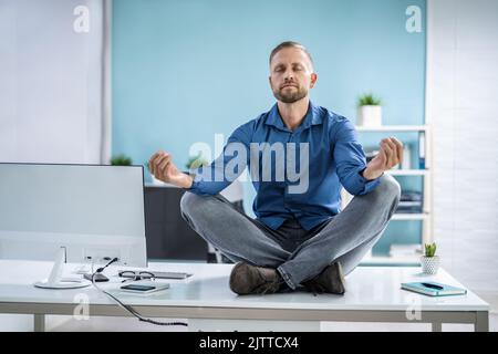 Mitarbeiter Macht Yoga-Meditation Für Psychische Gesundheit Im Büro Stockfoto