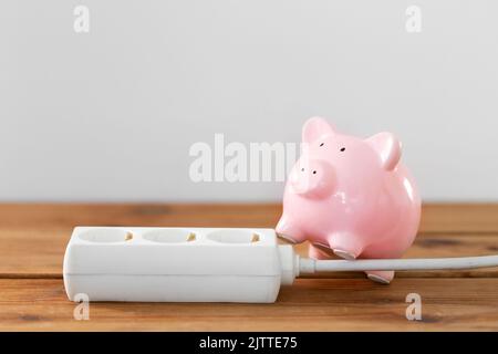 Nahaufnahme von Sparschwein und Steckdose Stockfoto