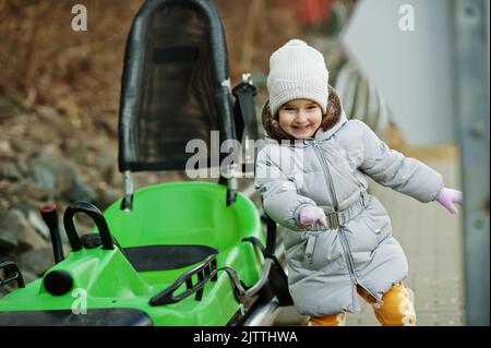 Mädchen stehen in der Nähe der elektrischen Schlittenfahrt auf Schienen. Stockfoto