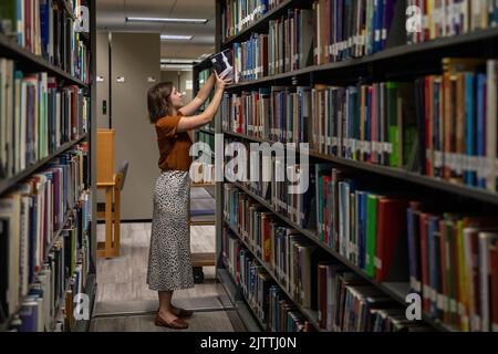 Texas, USA. 1. September 2022. Ein Student des Arbeitsstudiums stellt ein Bücherregal mit Büchern auf, die Studenten an der Baylor University in Waco, Texas, USA, am 28. August 2022 zurückgegeben haben. Quelle: Xin Jin/Xinhua/Alamy Live News Stockfoto