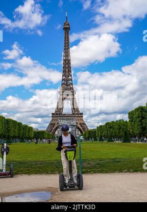 Touristen besuchen die Stadt in der Nähe des Eiffelturms während einer geführten Segway-Tour durch Paris Stockfoto