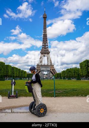 Touristen besuchen die Stadt in der Nähe des Eiffelturms während einer geführten Segway-Tour durch Paris Stockfoto