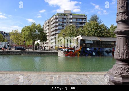 Hübsche Sommeransicht eines Bootes auf dem Bassin de la Villette in Paris, Frankreich. Stockfoto