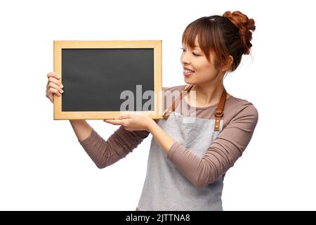 Glückliche Frau im Schürze mit Kreidetafel Stockfoto