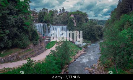 Luftdrohnenpanorama der Pliva-Wasserfälle in Jajce, bosnien und herzegowina. Zuschauer, die an einem bewölkten Tag die Wasserfälle betrachten. Stockfoto