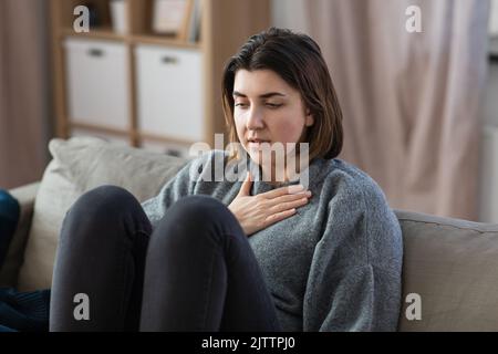 Traurige Frau, die zu Hause einen Panikanfall hat Stockfoto