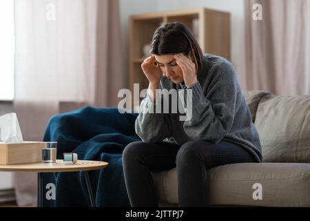 Gestresste Frau mit Medikamenten, die Kopfschmerzen hat Stockfoto