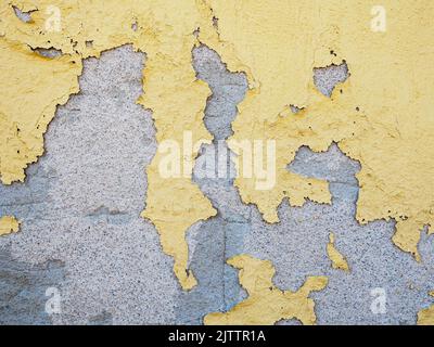 Abblätternde gelbe Farbe auf Betonwand Stockfoto