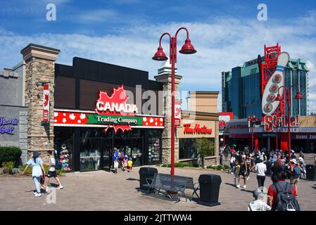 Niagara Falls, Kanada - 13. August 2022: Canada Trading Company, Tim Horton's und andere Touristenattraktionen auf der belebten Straße Clifton Hill. Stockfoto