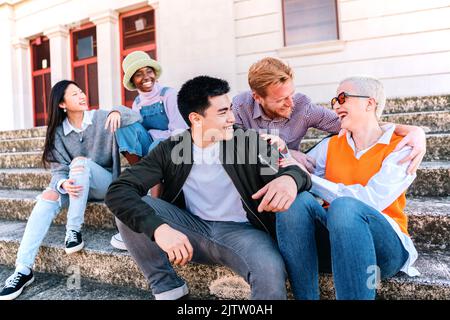 Eine Gruppe von multiethnischen Freunden, die zusammen talinkg sitzen und Spaß haben Stockfoto