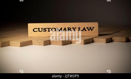 Gewohnheitsrecht auf Holzoberfläche geschrieben. Recht und Staat. Stockfoto