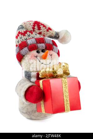 Lächelndes handgemachtes Schneemann-Spielzeug gekleidet in Schal und Mütze mit roter Geschenkbox mit goldener Schleife isoliert auf weißem Hintergrund. Symbol für Weihnachten und Neujahr Stockfoto