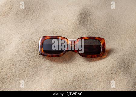 Tortoiseshell Sonnenbrille am Strand Sand Stockfoto