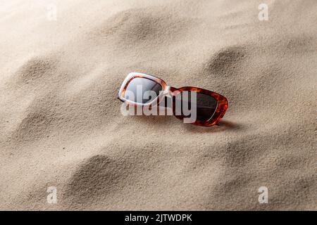 Tortoiseshell Sonnenbrille am Strand Sand Stockfoto