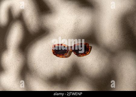 Tortoiseshell Sonnenbrille am Strand Sand Stockfoto