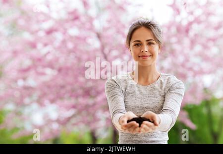 Frau mit einer Handvoll Erde im Frühlingsgarten Stockfoto