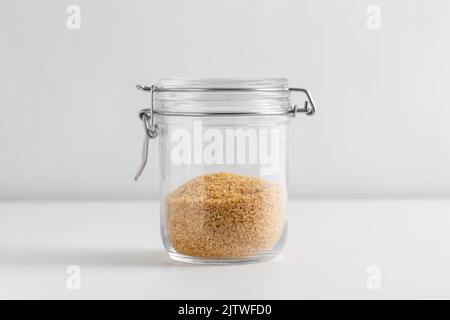 Nahaufnahme des Glases mit Bulgur auf dem weißen Tisch Stockfoto