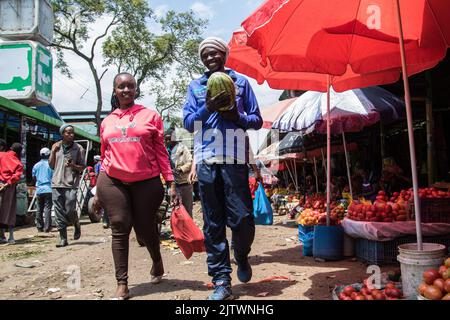 Nakuru, Kenia. 01. September 2022. Auf einem Frischemarkt in Nakuru Town laufen Menschen an Sonnenschirmen vorbei, die Tomaten bedecken. Die Inflation in Kenia stieg im August, dem Monat, in dem die Parlamentswahlen stattfanden, auf 8,5 %, wobei die Nahrungsmittelinflation bei 15,3 % lag. Der Anstieg ist seit März 2022 im Aufwärtstrend. Kredit: SOPA Images Limited/Alamy Live Nachrichten Stockfoto