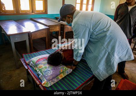 Kayah State, Myanmar. 28. August 2022. Ein Arzt von 'Nway Oo Sayy Aid' überprüft den Patienten im IDP-Lager. „Nway Oo Sayy Aid“ („Spring Medical Bag“ in burmesischer Sprache), der Name des medizinischen Teams, das sich um die Karen-Flüchtlinge im Bundesstaat Kayah kümmert, ging in ein IDP-Lager, wo etwa 300 Menschen leben, um medizinische Untersuchungen durchzuführen. Dieses medizinische Team dient der medizinischen Notversorgung hauptsächlich in Kriegsgebieten und Flüchtlingslagern im Bundesstaat Kayah. (Bild: © Kaung Zaw Hein/SOPA-Bilder über ZUMA Press Wire) Stockfoto