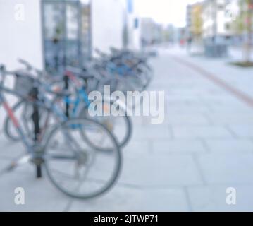 Bereit zum Fahren. Verschwommene Aufnahme eines Fahrrads an einem Fahrradständer in einer Stadt. Stockfoto