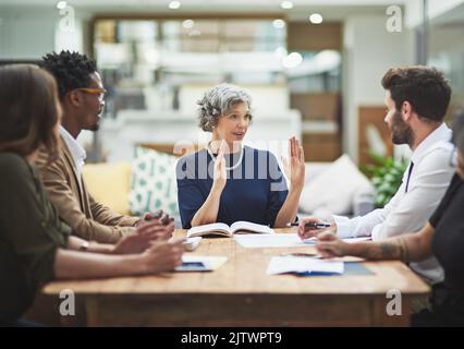 Wir konzentrieren uns auf das Gesamtbild. Eine vielfältige Gruppe von Geschäftsleuten, die in ihrem modernen Büro eine Besprechung abhalten. Stockfoto