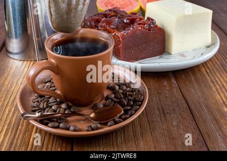 Nahaufnahme von Kaffeebohnen, umgeben von Tasse, Filtertuch und Guava-Süß- und Quark. Stockfoto