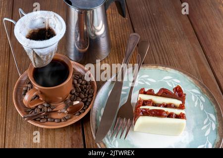 Guava-Süß- und Quark-Scheiben neben Besteck, Tasse, Bohnen und Stoffkaffeefilter. Stockfoto