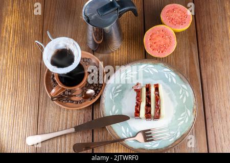 Guava-Süß- und Quark-Scheiben neben Besteck, Tasse, Bohnen und Stoffkaffee Filter top view. Stockfoto