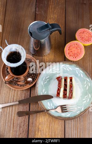 Guava-Scheiben für süßen und Quark neben Besteck, Tasse, Bohnen und Stoffkaffee Filter vertical top view. Stockfoto