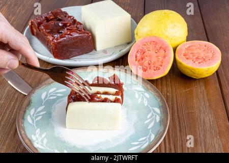 Mann mit einer Gabel bereit, Scheiben von Guava süß und Quark schneiden. Stockfoto