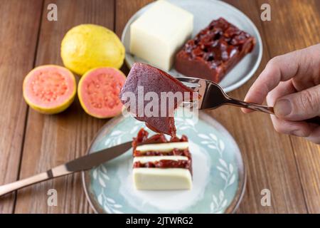 Nahaufnahme einer süßen Guava-Scheibe mit einem Bissen. Im Hintergrund Quark und Guava süß in einer Bar. Stockfoto