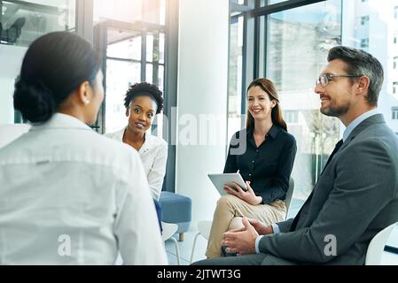 Sie haben ein gutes Gefühl über diesen Kandidaten. Eine Gruppe von Geschäftsleuten, die einen potenziellen Mitarbeiter im Sitzungssaal interviewten. Stockfoto