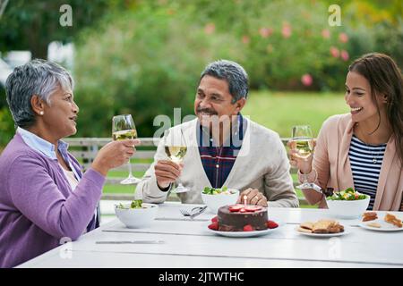 Viele glückliche Rückkehr, meine Liebe. Eine Familie genießt ein Geburtstagsessen draußen. Stockfoto