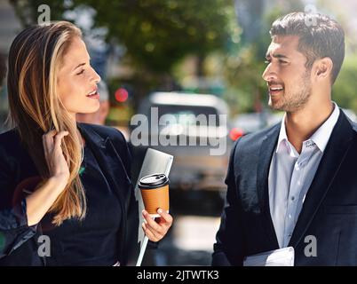 Frische Luft und freundliches Geschwätz auf ihrer Pause draußen. Zwei Kollegen aus dem Unternehmen, die eine Diskussion, während sie die Straße hinunter. Stockfoto