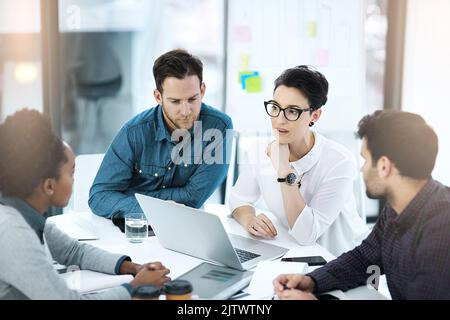 Die Planung ist nur der Anfang einer weiteren Erfolgsgeschichte: Eine Gruppe von Kollegen, die in einem Büro gemeinsam an einem Laptop arbeiten. Stockfoto