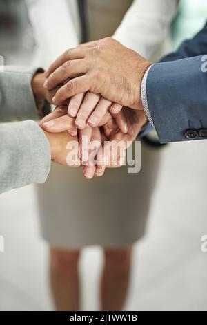 Der Sieg wird bald unser sein. Nahaufnahme einer Gruppe von Geschäftsleuten, die sich in Einheit zusammenschließen. Stockfoto