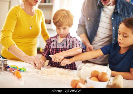 Sie teilen die Liebe zum Backen. Eine Familie, die zu Hause zusammen bäckt. Stockfoto