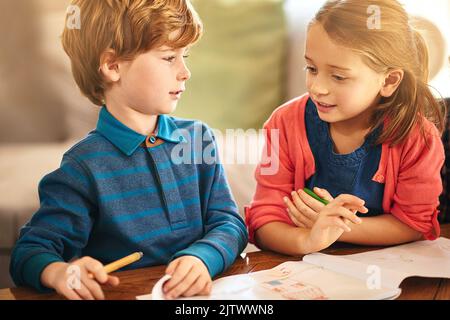 Malspaß mit der kleinen Schwester. Ein Bruder und eine Schwester färben zusammen. Stockfoto