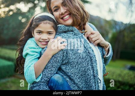 Meine Tochter, die Freude meines Lebens. Porträt einer glücklichen Mutter und Tochter, die eine Huckepack-Fahrt im Freien genießen. Stockfoto